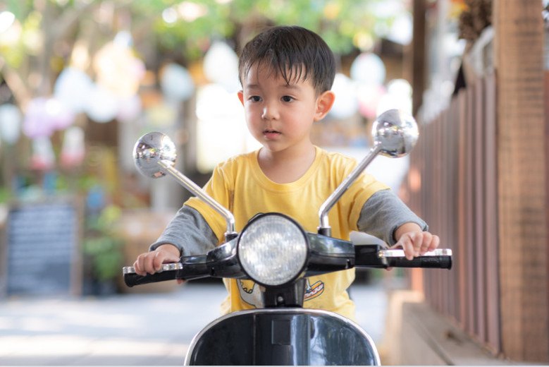 anak kecil mengendarai sepeda motor